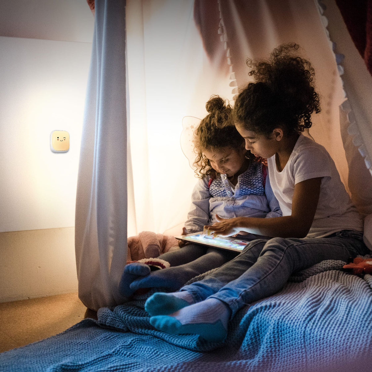 Twee kinderen lezen samen in bed bij het zachte schijnsel van een Numsy nachtlampje